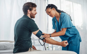 Portrait of radiologist smiling while colleague preparing patient for xray in examination room