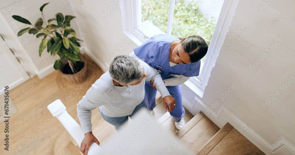 nurse helping woman get up the stair