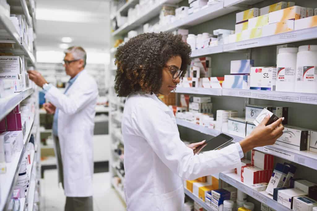 two florida pharmacy technicians walking around and doing stock inside of a pharmacy