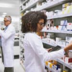 Shot of two focused pharmacist walking around and doing stock inside of a pharmacy