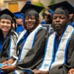 A group of Nursing graduates sitting at an FVI graduation ceremony in their robes with their FVI stoles