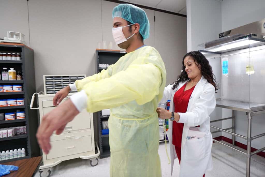 professor pepper putting PPE on student