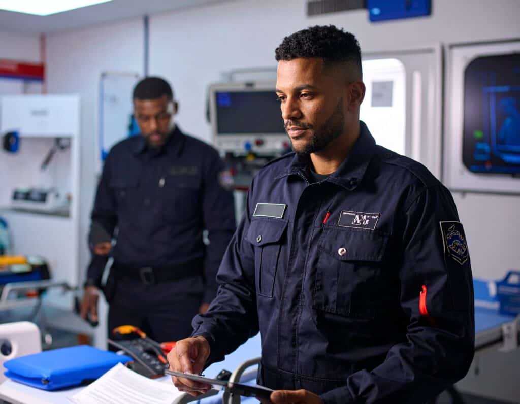 EMT trainee in uniform studying inside a paramedic training classroom.