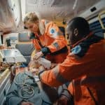EMT training program in Miami and Miramar. EMTs providing emergency care to a patient inside ambulance